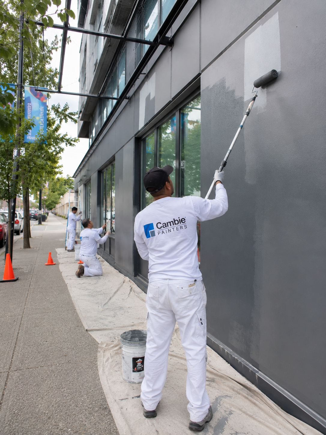 Commercial painters scaling a building exterior on scaffolding in Vancouver